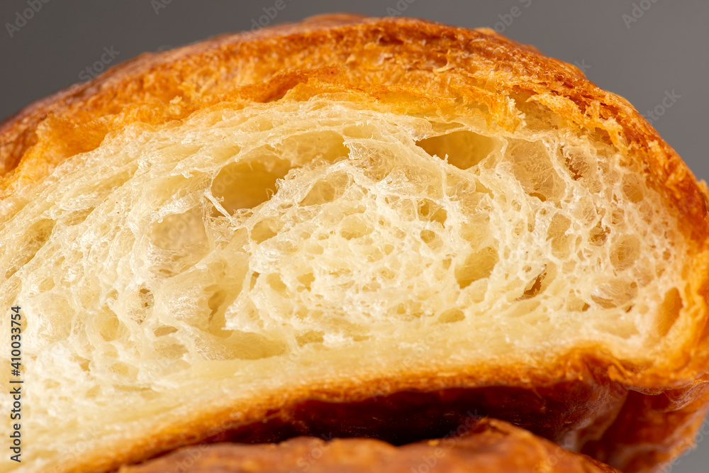 Detailed and closeup photo of a fresh baked plain buttery and flaky croissant.