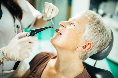 Senior female patient on a dentist appointment. Regular check up at orthodontist. Specialist examining a older patient. Dental prosthetics implant for retired pensioner woman