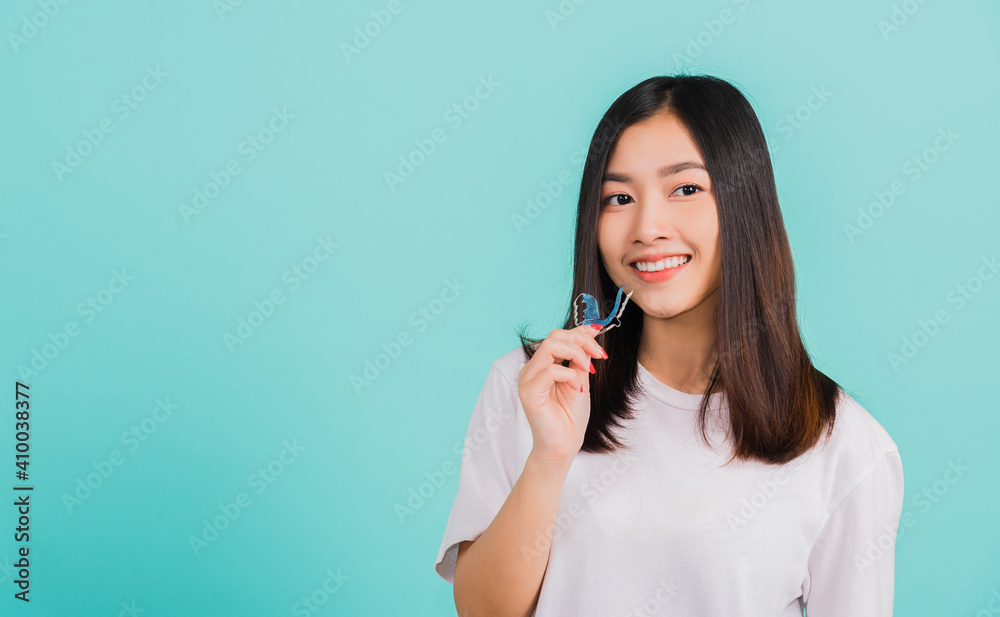 woman smiling holding silicone orthodontic retainers for teeth