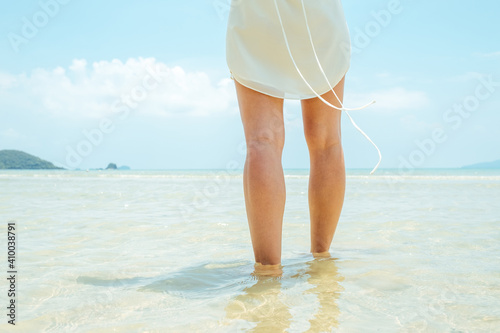 Low angle woman walking barefoot on the beach