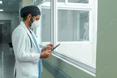 Doctor checking his tablet in the corridor of a hospital