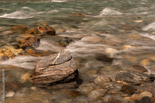Closeup of a clear, fast-running stream rushing over its bouldery bed. Makarora River, Mount Aspiring National Park, Otago, New Zealand.