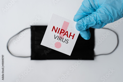 Nipah virus. Nipah Henipavirus is a newly emerging bat-borne virus that causes acute respiratory illness. nipah virus infection, protective medical face mask and medical gloves. 