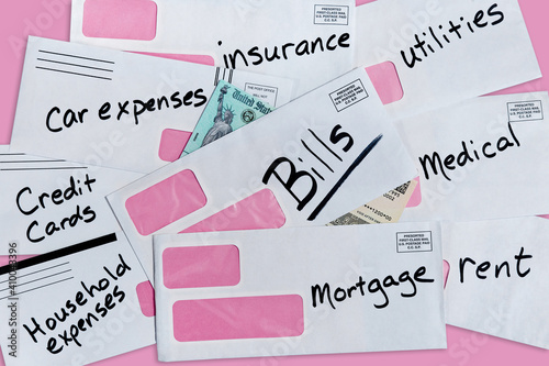 фотографія United States stimulus check partially buried under multiple bills and envelopes