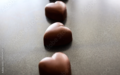 Valokuva Chocolate heart candy on a dark background, romantic food concept
