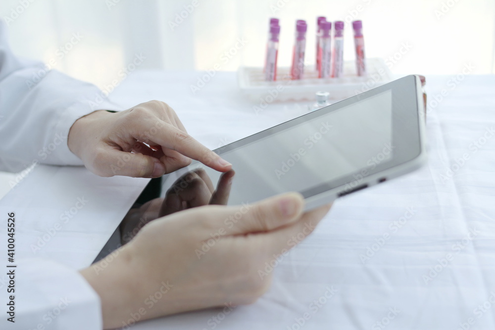 Fototapeta premium Doctor hands use a tablet, hospital lab, on the work table,Working doctor,white office of the hospital, healthcare concept