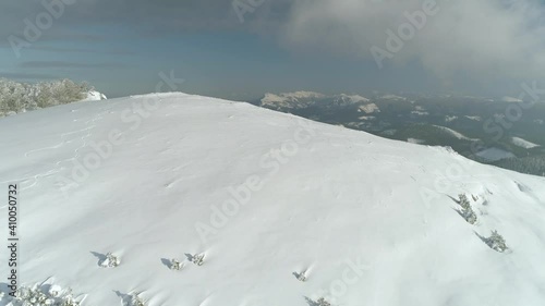 Stunning drone shot over the peak of a snow-covered mountain to reveal a beautiful snow-capped mountain range in the Western Basque Country of Spain. photo