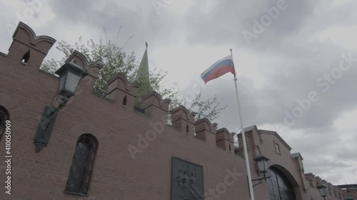 Russian flag by Kremlin wall with Arsenal guard commemorative plaque, Moscow