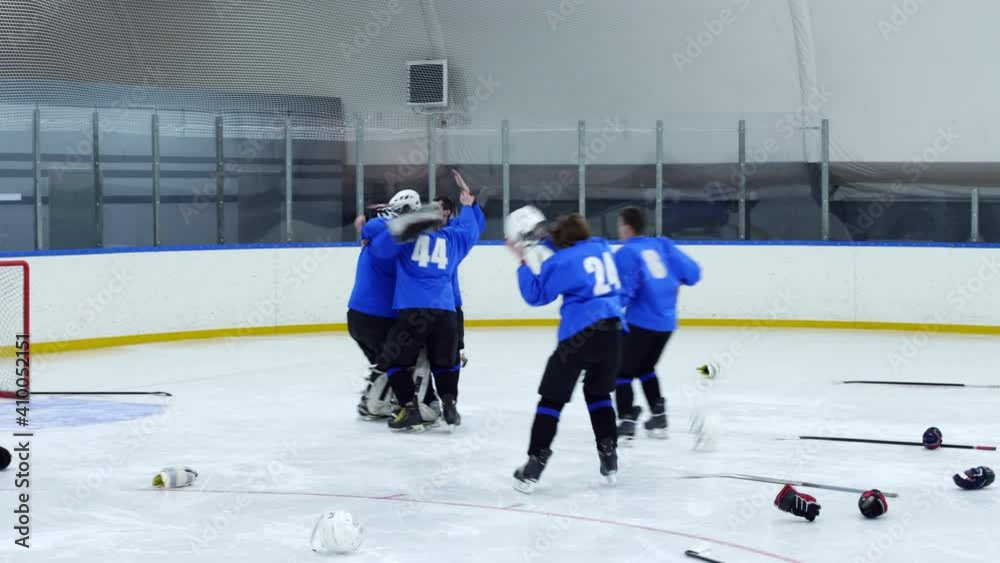 Excited hockey players throwing away helmets and sticks, skating to