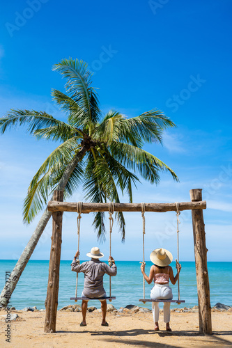 couple sitting on swing by the sea © Sunanta