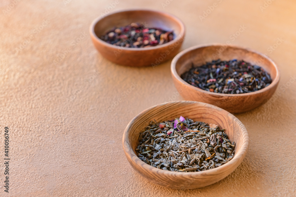 Wooden bowls with dry tea leaves on table