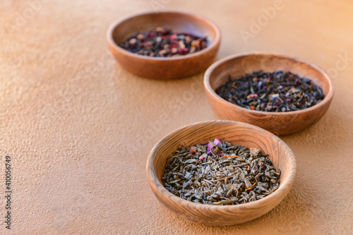 Wooden bowls with dry tea leaves on table