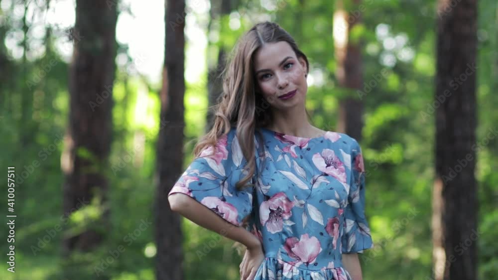 Portrait of a young beautiful woman, nature with a forest in the background. She is confident and smiling. Summer in the forest. Portrait of a young beautiful woman, nature with a forest in the background. She is confident and smiling. Summer in the forest.