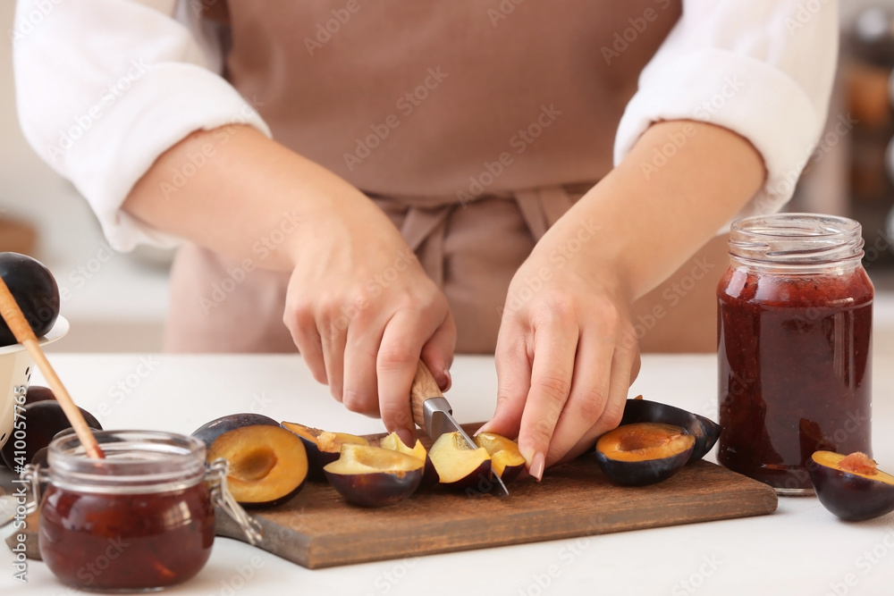 Woman cutting plums for preparing delicious jam Woman cutting plums for preparing delicious jam