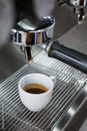 Modern coffee machine with cup of hot espresso in cafe  closeup