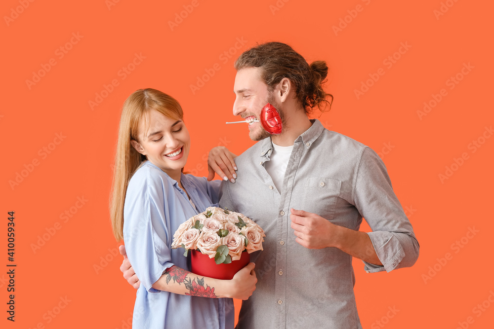 Young couple with flowers and air balloon on color background. Valentine's Day celebration Young couple with flowers and air balloon on color background. Valentine's Day celebration