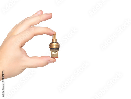 Plumber holds in hand a faucet axle on a white background, isolate. The concept of a leakage strap in the mixer tap when replacing the valve faucet axle. Copy space for text