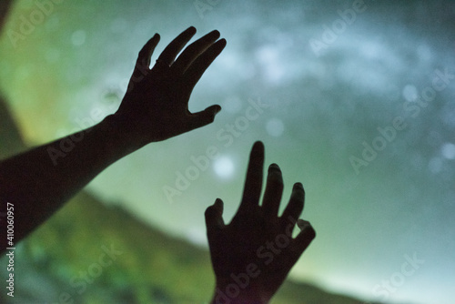 Girl reaching towards the planets at the planetarium