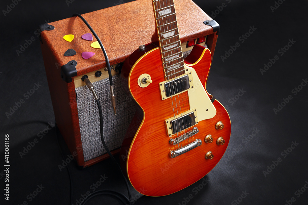 Fototapeta premium Tube combo amplifier for guitar with guitar on black background.