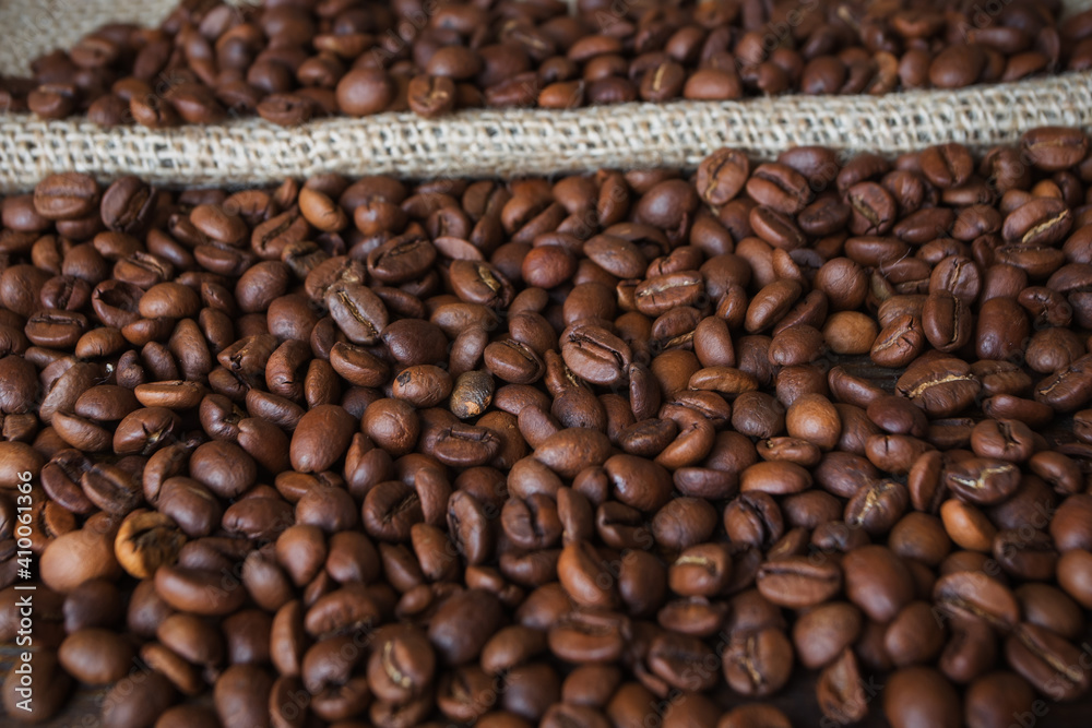 Obraz premium Background of coffee beans. Roasted coffee beans on a wooden table.