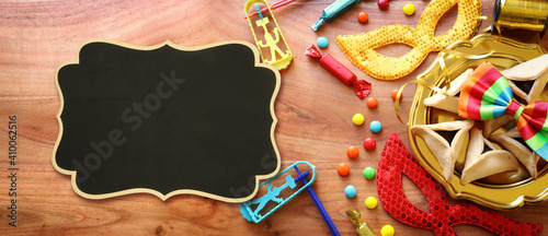 Purim celebration concept (jewish carnival holiday) over wooden background. Top view, flat lay