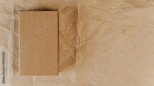 Brown cardboard box and wrapping paper. Top view, mockup. Place for logo, announcement, text. Gift, delivery concept