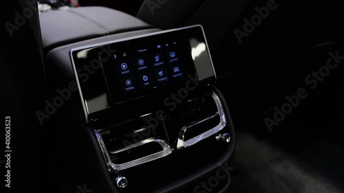 Touchscreen control panel for all basic functions of passengers in the cabin of a luxury car. Closeup cinematic 4k shot