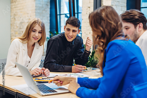 Businesswoman showing on laptop to colleagues