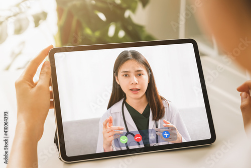 Woman making video call to doctor on tablet and provide help online counseling. Concept working from home. © sitthiphong
