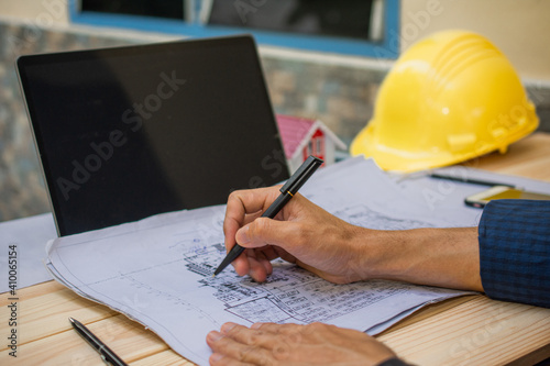 Engineer check drawing blueprint to work for building construction house