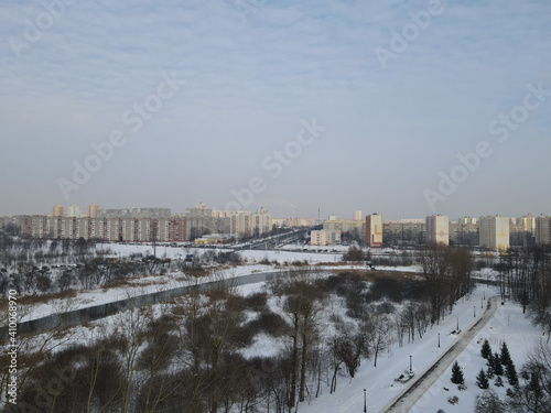 Urban winter landscape from above. Multi-storey buildings and trees in the city park are visible. © f2014vad