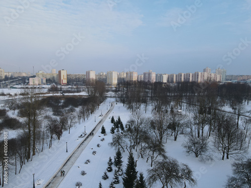 Urban winter landscape from above. Multi-storey buildings and trees in the city park are visible.