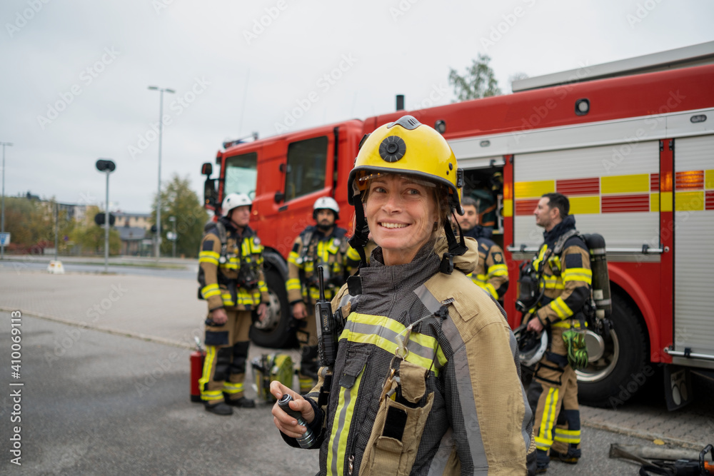 Female firefighter in front of fire engine Female firefighter in front of fire engine