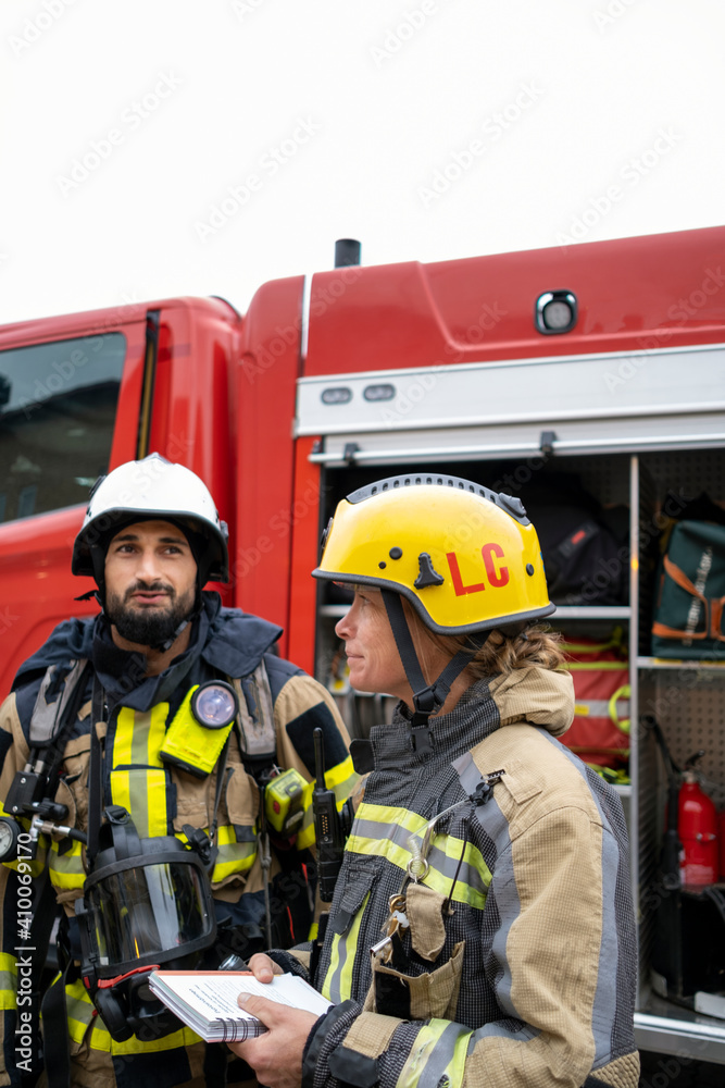 Firefighters in front of fire engine Firefighters in front of fire engine