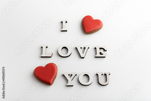 Romantic inscription I LOVE YOU and heart shaped gingerbread cookies on white background. Valentines day