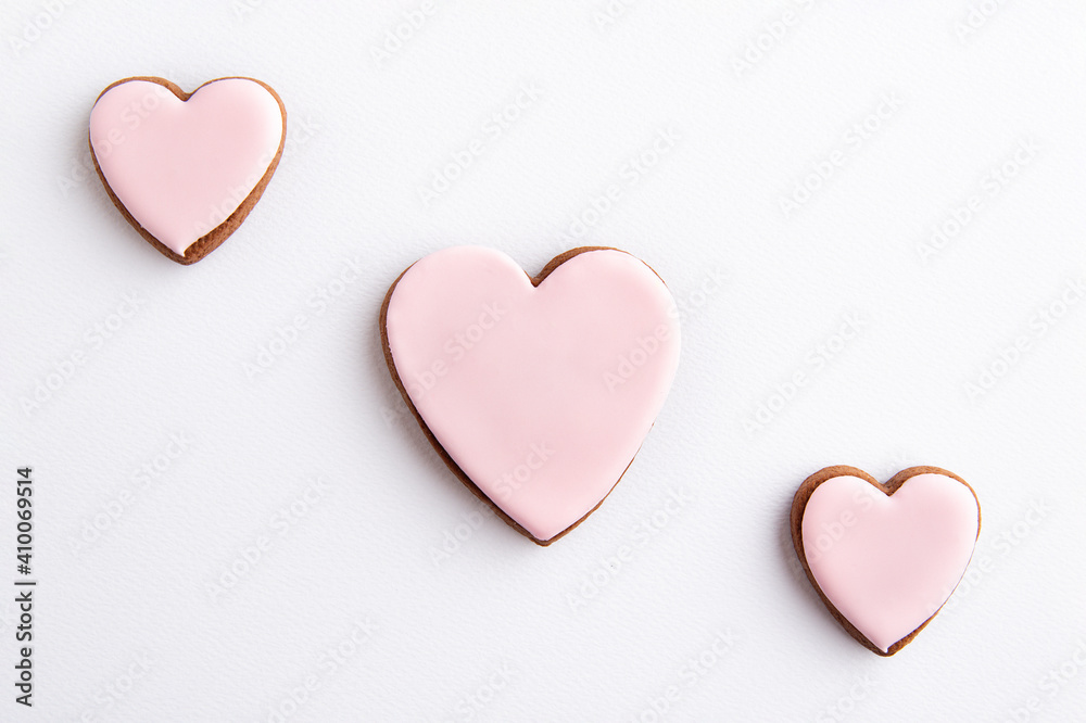 Three cookies-hearts with sugar icing on white background. Mothers day. Womans day. Valentines Day. Love.