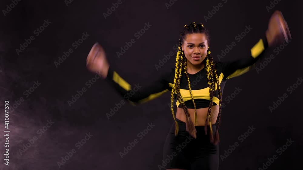 Beautiful young woman on black background. Beauty shot with braids hair in motion