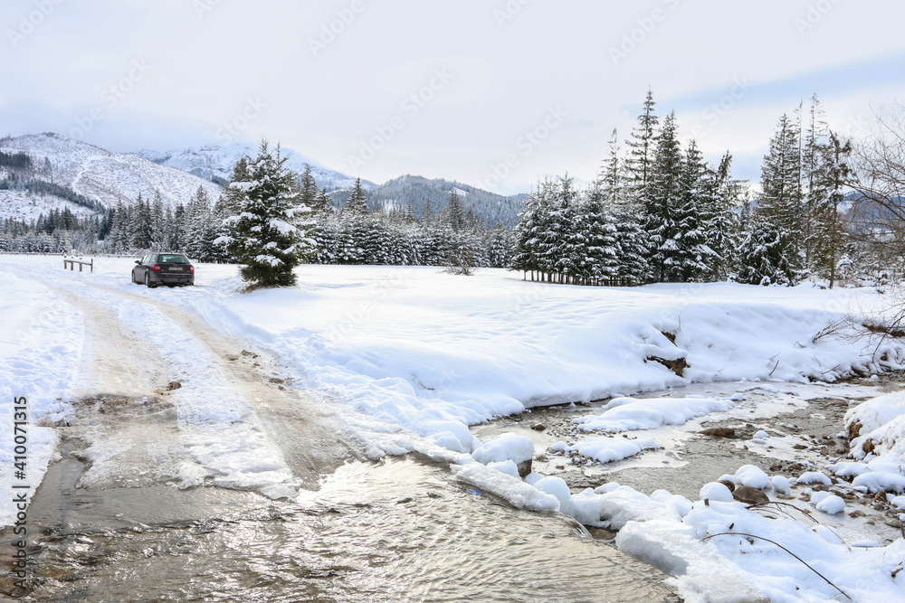 ZAKOPANE, POLAND - JANUARY 28, 2021: Banks of a mountain stream covered with snow, winter landscape. ZAKOPANE, POLAND - JANUARY 28, 2021: Banks of a mountain stream covered with snow, winter landscape.