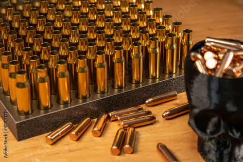 Obraz na plátně In the foreground are bullets in a shell, casings in a wooden stand on a black b