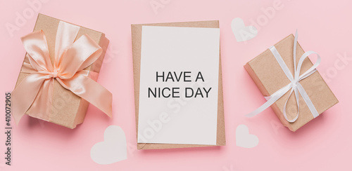 Gifts with note letter on isolated pink background, love and valentine concept with text HAVE A NICE DAY © Daria Lukoiko