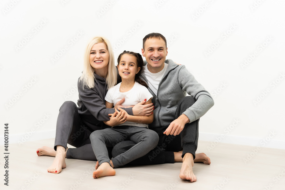 happy young family sitting on floor with home concept happy young family sitting on floor with home concept