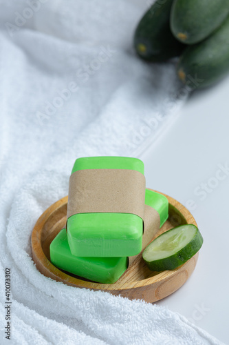 Cucumber slices and soap on white background