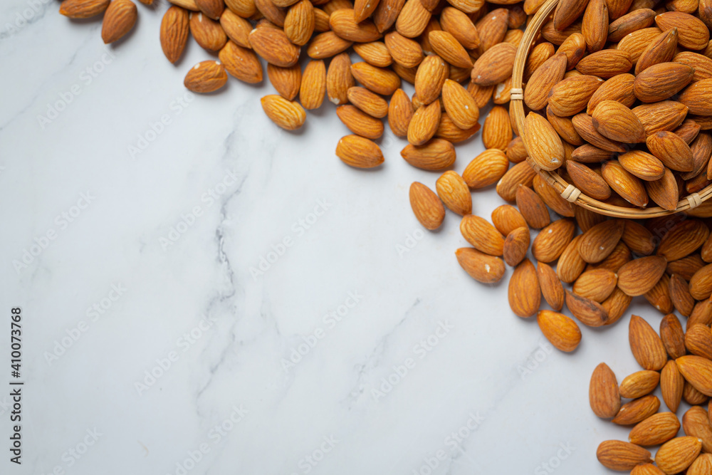 Almonds in bowl on marble background
