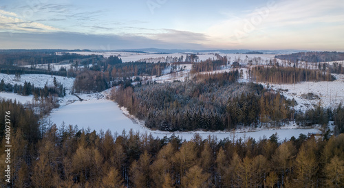 Aerial bird view of beautiful winter landscape with frozen water reservoir situated in forest covered with snow. European countryside. Czech Republic  Vysocina Highland region  Europe
