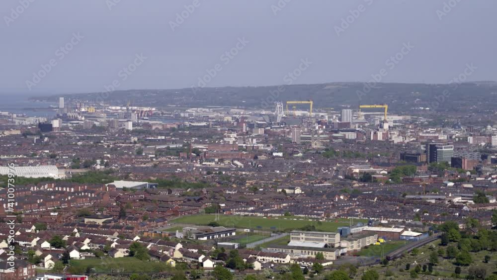 Aerial flyover of west Belfast from the countryside looking towards the city centre or center Aerial flyover of west Belfast from the countryside looking towards the city centre or center