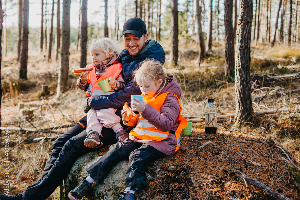Father and daughters having picnic in forest Father and daughters having picnic in forest