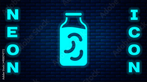 Glowing neon Pickled cucumbers in a jar icon isolated on brick wall background. Vector.