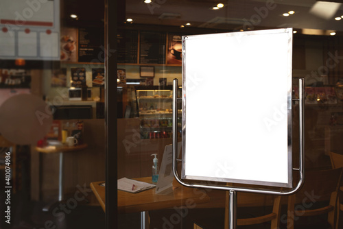 Mockup white poster or white paper promotion displayed on the front of the restaurant, coffee shop promotion information for marketing announcements and details