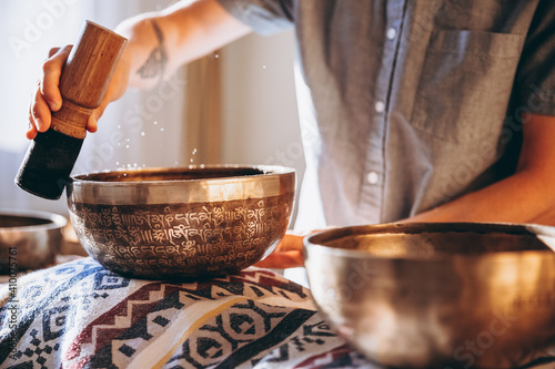 Spa with a masseur and a client who have a relaxing massage with Tibetan music bowls