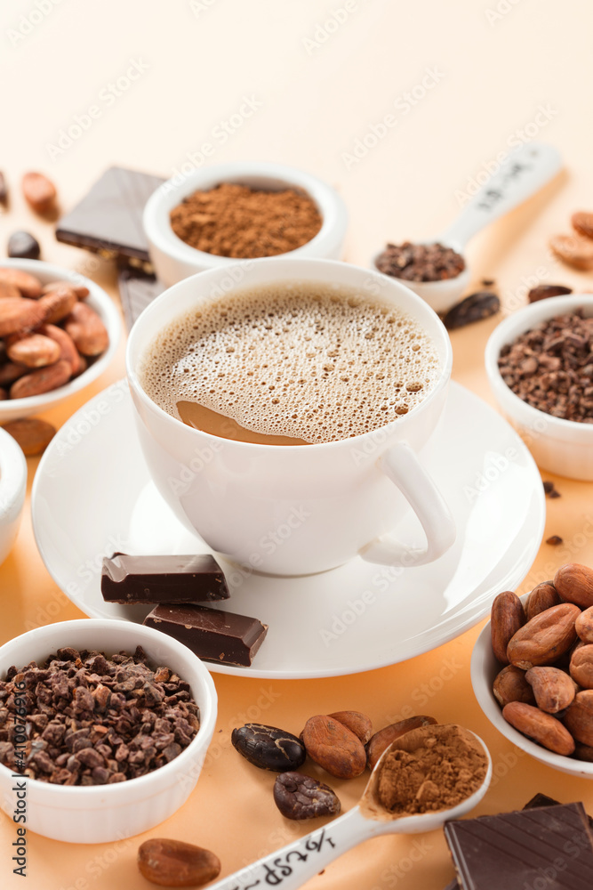 Bowls with aromatic cocoa beans, cocoa nibs, cocoa powder and cup of hot chocolate on natural paper background. Bowls with aromatic cocoa beans, cocoa nibs, cocoa powder and cup of hot chocolate on natural paper background.